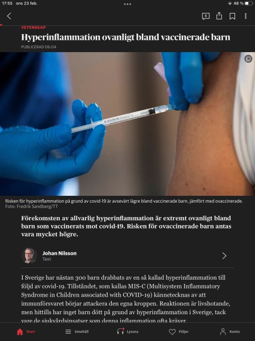 Person får COVID-19-vaccinering, närbild på händer som håller en spruta nära överarmen.