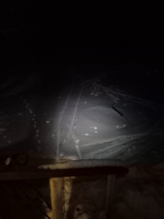 Bild på skidspår i snön sett från en veranda på kvällen.