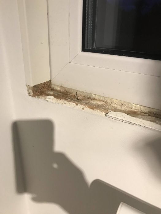 Svullen fönsterkarm med synliga fuktspår och smuts vid ett nyligen installerat Drutex PVC-fönster.