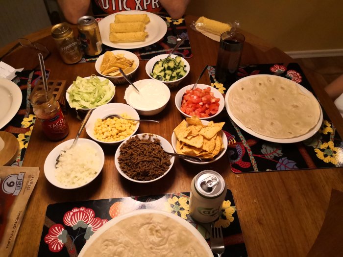Middagsbord dukat med tacoingredienser som malet kött, tortillas och grönsaker.