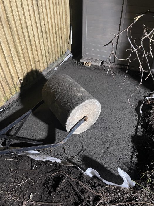 Betongblandare och nylagd cement vid kvällsbelysning.