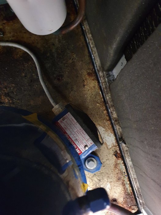 Interiör av värmepump med synliga rör och komponentetikett.