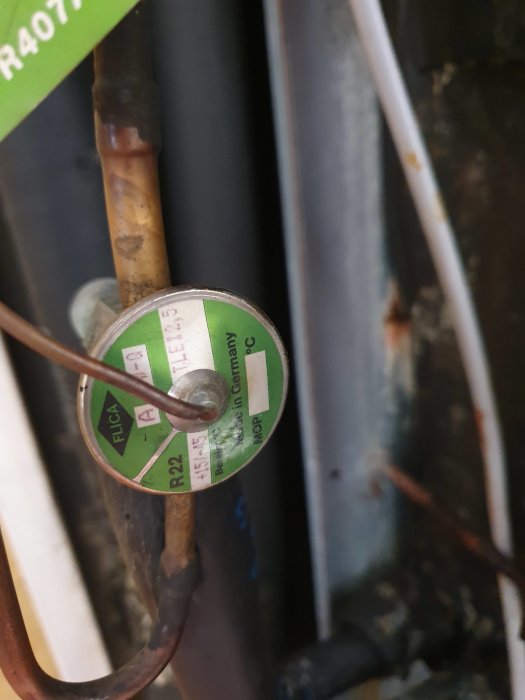 Närbild på en komponent i en värmepump med etiketten 'R407C' indikerande köldmedium.