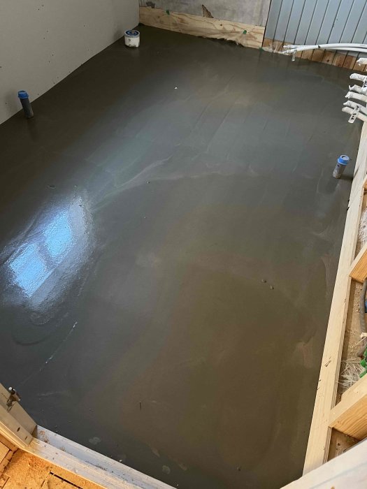 Nyligen spacklat golv med första lagret i renoveringsprojekt, förberett för värmekabel.