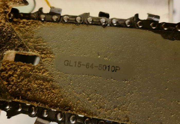 Närbild på en motorsågskedja och svärd med märkningen GL15-64-5010P.