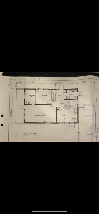 Arkitektritning av ett bottenvåningsplan med tydligt markerade rum som vardagsrum, kök, bad och sovrum.