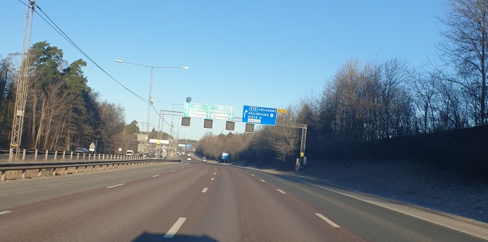 Väg med vägskyltar som visar riktningar för Sundsvall, Arlanda och väg E4/E20.