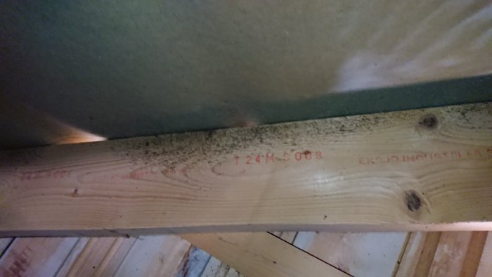 Takstol på vind med svarta prickar som misstänks vara mögel vid ventilationsöppning.