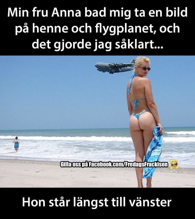 Kvinna i bikini håller en handduk på en strand, litet barn vid vattenkanten och ett flygplan i bakgrunden.