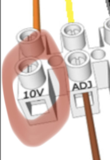 Otydlig bild av elektrisk kopplingsskema med markerat område och texten "10V" samt "ADJ".