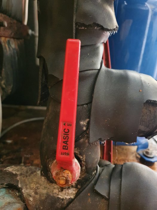 Rörmokararbete med röd Basic G6 buntband runt svart, skadad röranslutning.