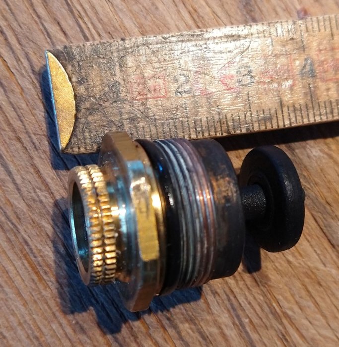 Ventilinsats bredvid ett smutsigt måttband på träyta, för byte till MMA-justering.