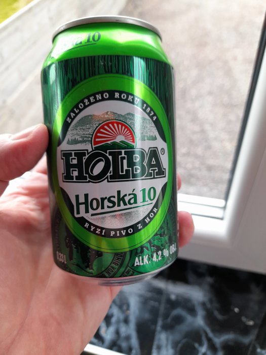 Hand håller en burk Holba Horská 10, en tjeckisk öl med 4,2% alkoholhalt.