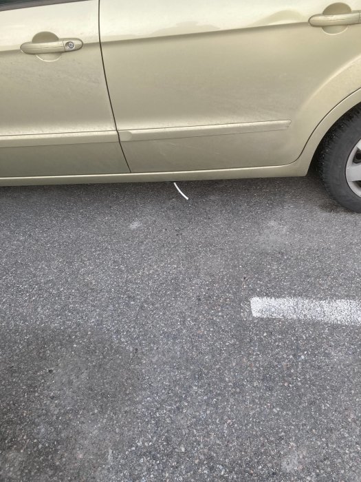 Del av bilens plåt som sticker ut vid sidan och ser ut att ha lossnat.
