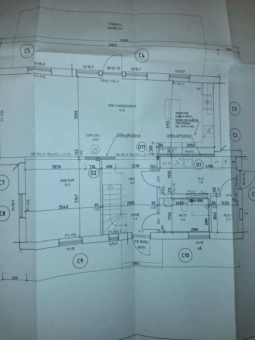 Arkitektonisk ritning av en husplan med mått och rumsmarkeringar.