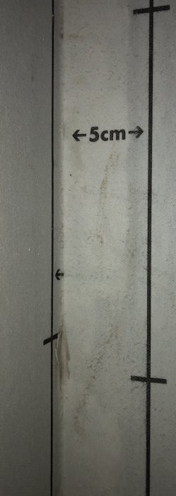 Måttmärkning på en vägg som visar 5 cm avstånd mellan två punkter med tydliga markerade linjer.