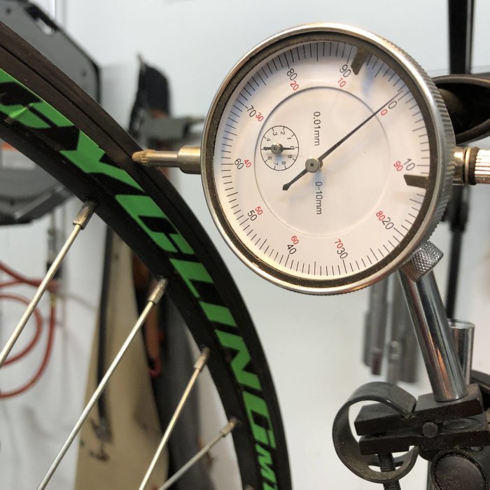 Mätdon används för att kontrollera raka hjul på en mountainbike med grön och svart fälg.