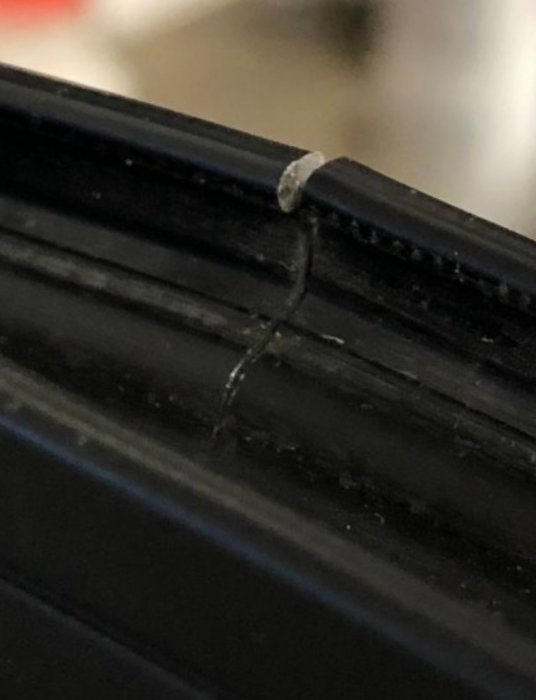 Närbild på en svart plaströrskarv med en synlig spricka längs skarven.