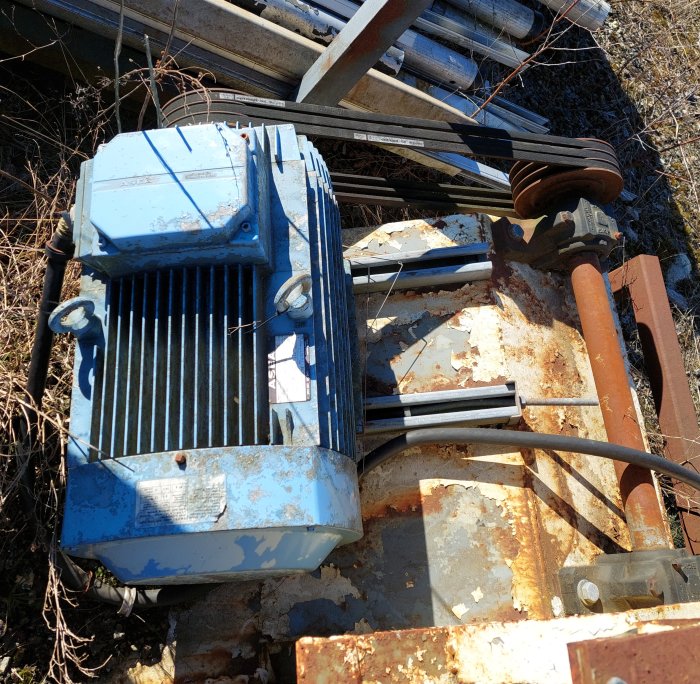 En rostig 22kw motor, stora hjul och trapetsskruv samlade för ett bandsågsverksbygge.