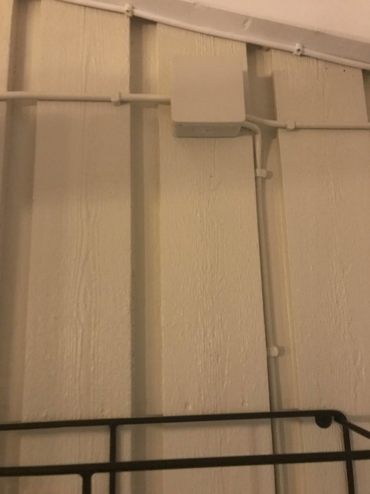 Elledningar monterade på en vit vägg med en eldosa, kopplingen ser nyligen ändrad ut.