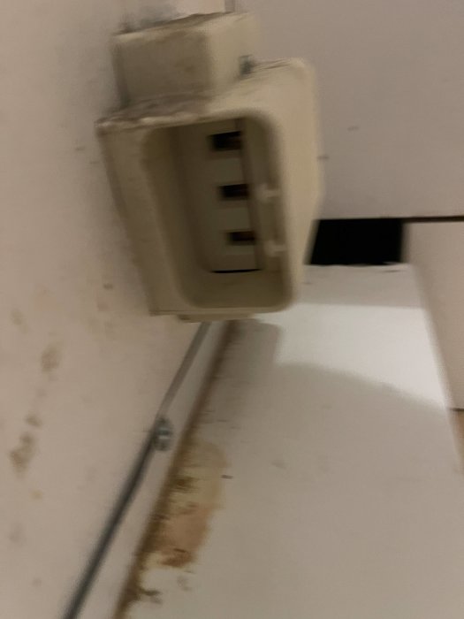 Gammalt smutsigt vägguttag för spis med öppen uttagsplatta och synliga kablar.