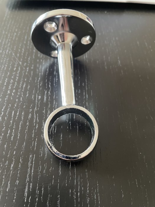 Kromad hållare för dusch eller klädstång med rund ring och väggfäste.