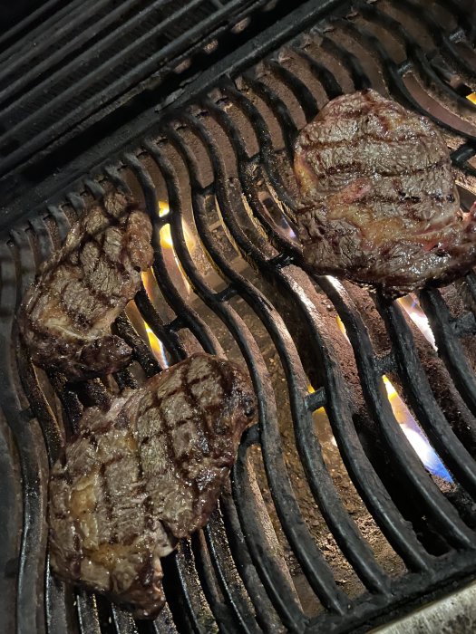 Australiensisk Black Angus-biffar som grillas på en grillrist.