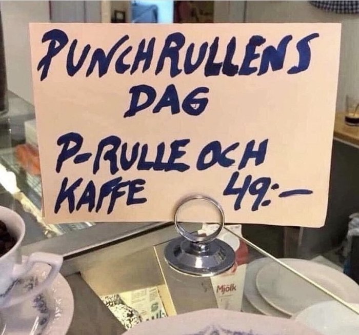 Skylt som annonserar "PUNCHRULLENS DAG P-RULLE OCH KAFFE 49:-" på en disken med kaffekoppar.