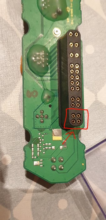 Kretskort med markerade lödpunkter och stift relaterade till strömavbrott i elektronisk enhet.