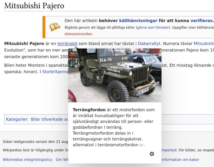 Jeep i militär utförande parkerad framför en Mitsubishi Pajero samt text från Wikipedia-sida