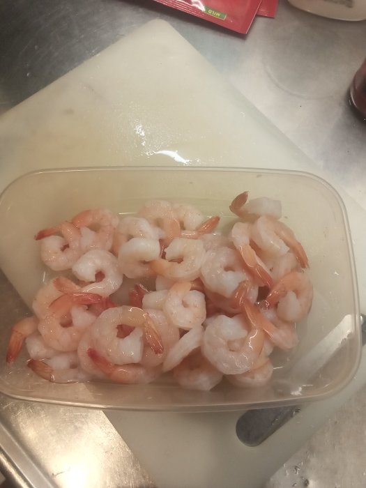 Räkor i plastlåda visande den rätta storleken för en maträtt.
