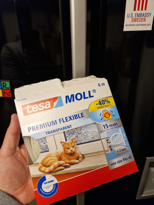 En hand som håller upp en förpackning av "tesa MOLL PREMIUM FLEXIBLE" tätlist.