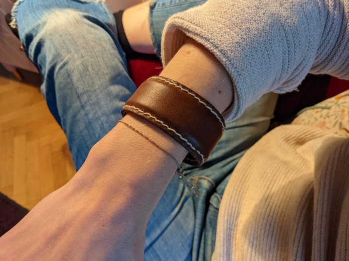 Hemmagjord läderarmband runt en persons handled som födelsedagspresent.