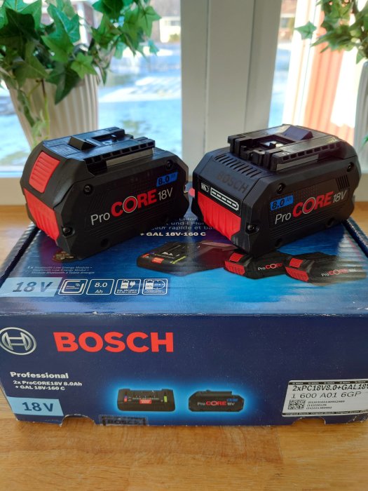 Två Bosch ProCORE 18V batterier och en snabbladdare på en förpackning.