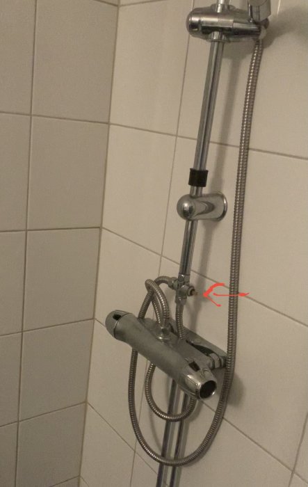 Duschsystem med vred markerat av en röd pil, vredet saknas.