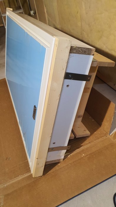 MidMade Lux A1120 vindslucka i förpackning med skyddande träbitar på sidorna och förmonterat foder.