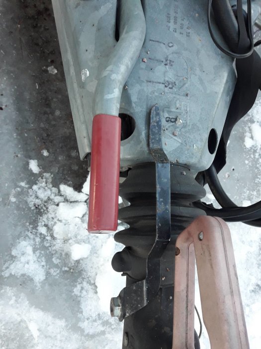 Närbild av en dragstång med fäst pil och suddiga markeringar ritade med spritpenna, på en snötäckt bakgrund.