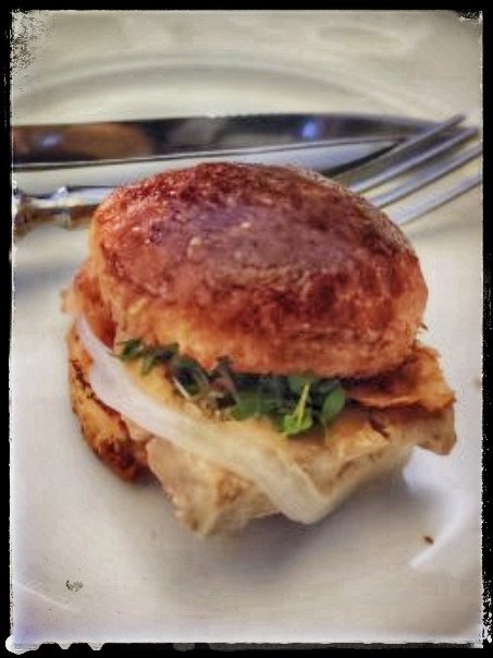 Liten ovanlig hamburgare med köttbulle istället för kött, lök och grönt, på tallrik med gaffel.