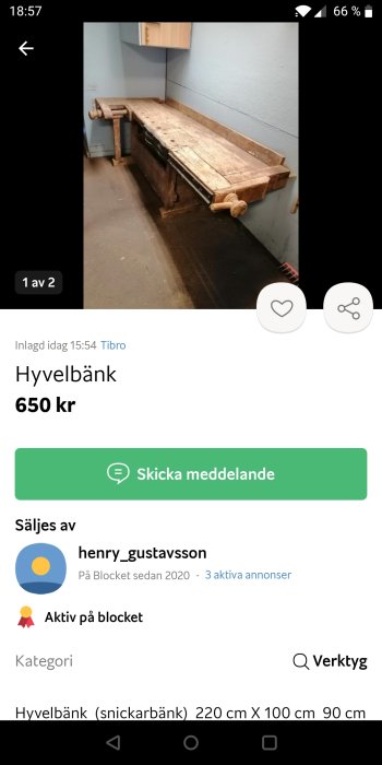 Lång hyvelbänk av trä med skruvtvingar i ett rum med blå väggar och ett vitt skåp.