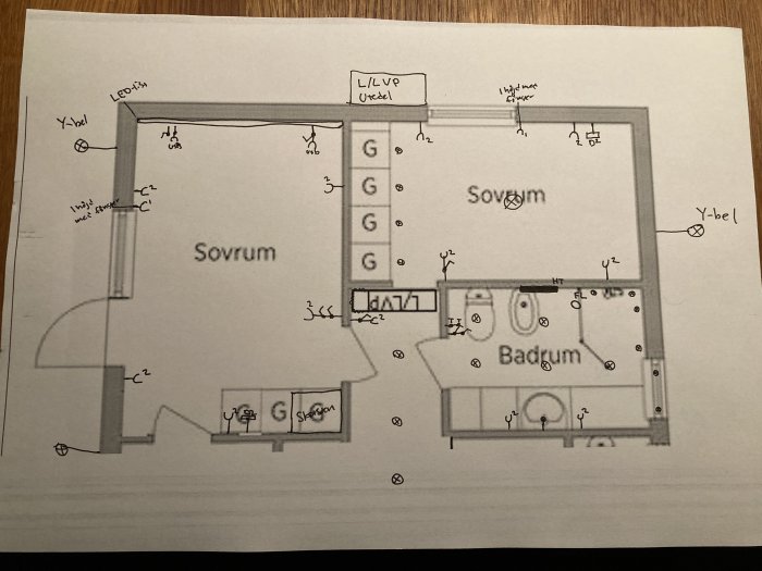 Handritad elinstallationsplan för en bostad med markerade positioner för belysning och uttag i olika rum.