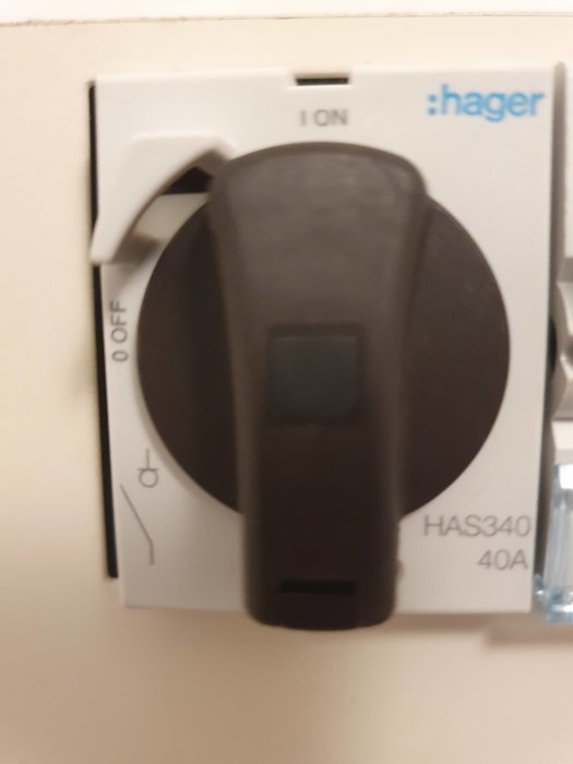Närbild på en Hager huvudbrytare på en vit vägg med märkningar "ON", "OFF" och modellnummer "HAS340 40A".