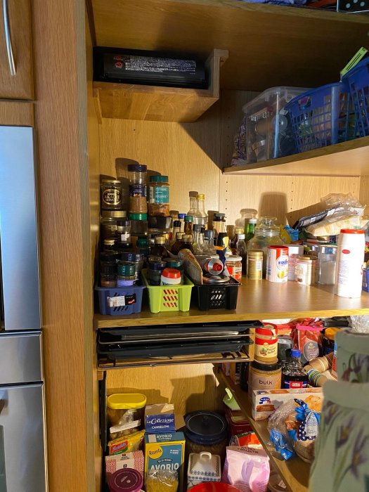 Hörnskåp med omlotthyllor och inbyggda fack för förvaring av ugnsplåtar och köksredskap.