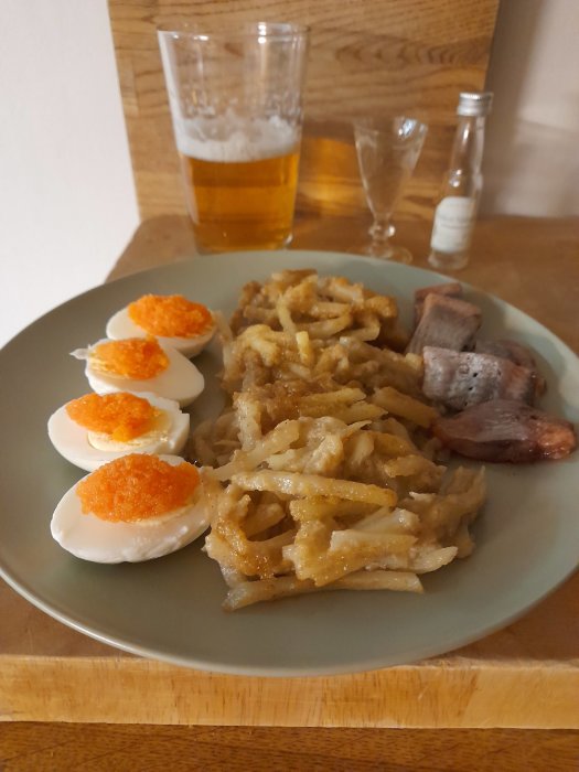 Svensk påskbord med ägg toppade med rom, Janssons frestelse, matjessill, öl och snaps.