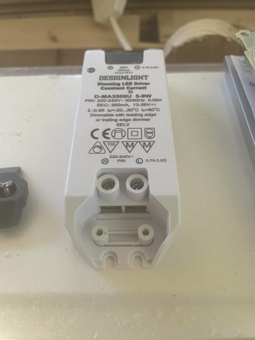 En transformator för LED-belysning med etikett och kopplingsklemmor synlig.