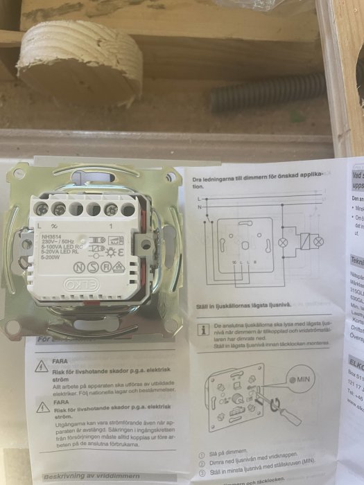 Dimmer och transformator på träyta med instruktionsmanual för elektrisk koppling.