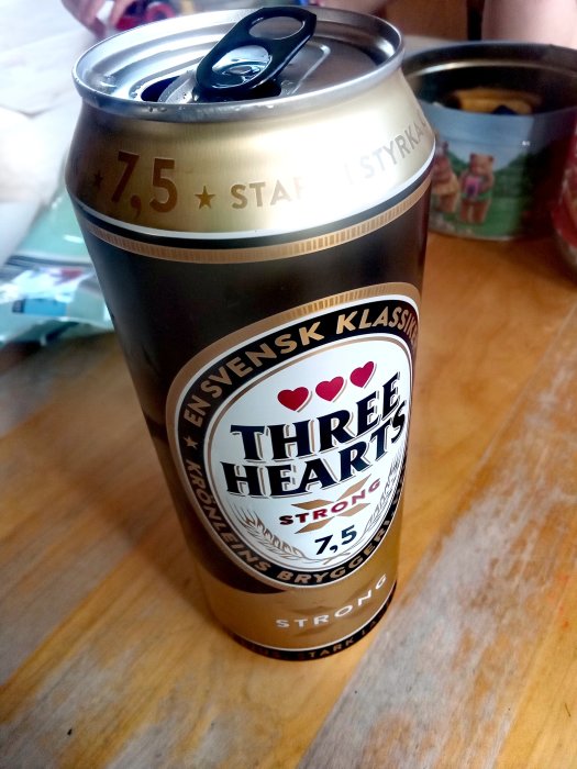 Öppnad ölburk på ett bord, märkt "Three Hearts Strong" med styrka 7,5%.