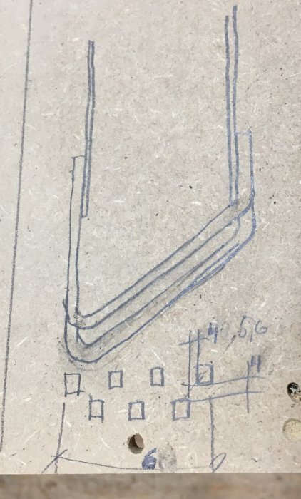 Handritad skiss av en ide för eldkorg i zigzagmönster med markerade mått och luftgenomströmning för pellets.