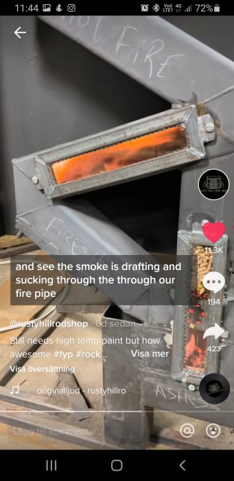 Metallrör med synliga flammor inuti, indikerar rökgång i byggprojekt.