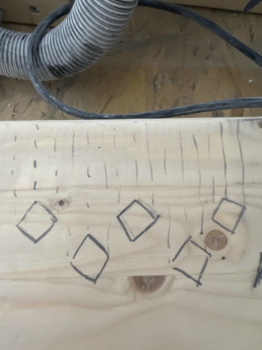 Skiss på träyta med diamantformer och markeringar föreställande stänger vridda 45 grader.