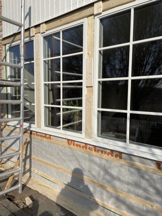 Nyinstallerade fönster med skarvat underbleck på en byggarbetsplats.